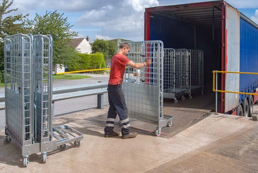 Um funcionário carrega roll containers alugados num camião