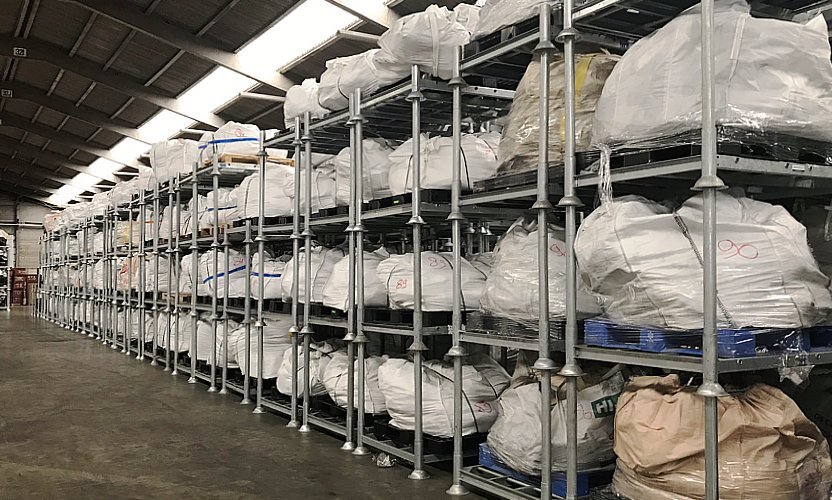 Paletes de plástico com bens armazenados temporariamente em racks móveis